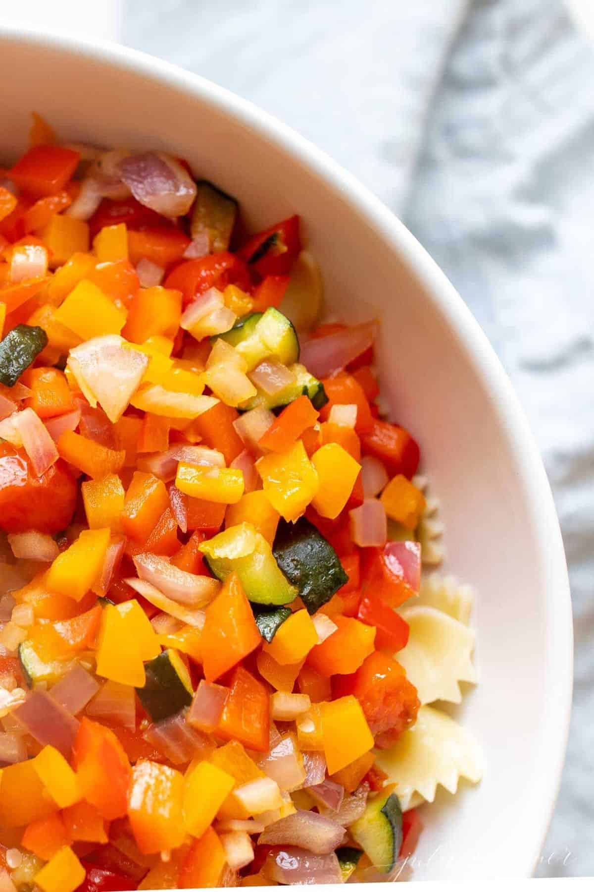 A white bowl filled with veggie pasta salad.