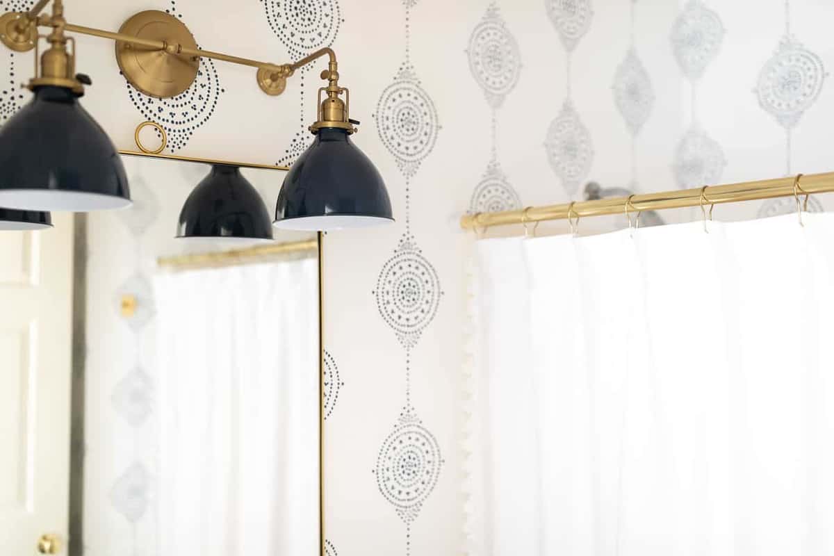 A navy and brass bathroom light fixture in a modern bathroom idea refresh.