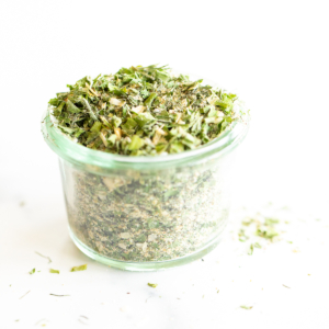 Glass jar of homemade ranch seasoning on a white countertop.