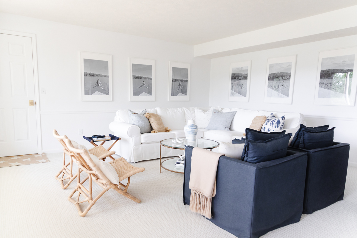 A living room with navy blue chairs and white furnishings.