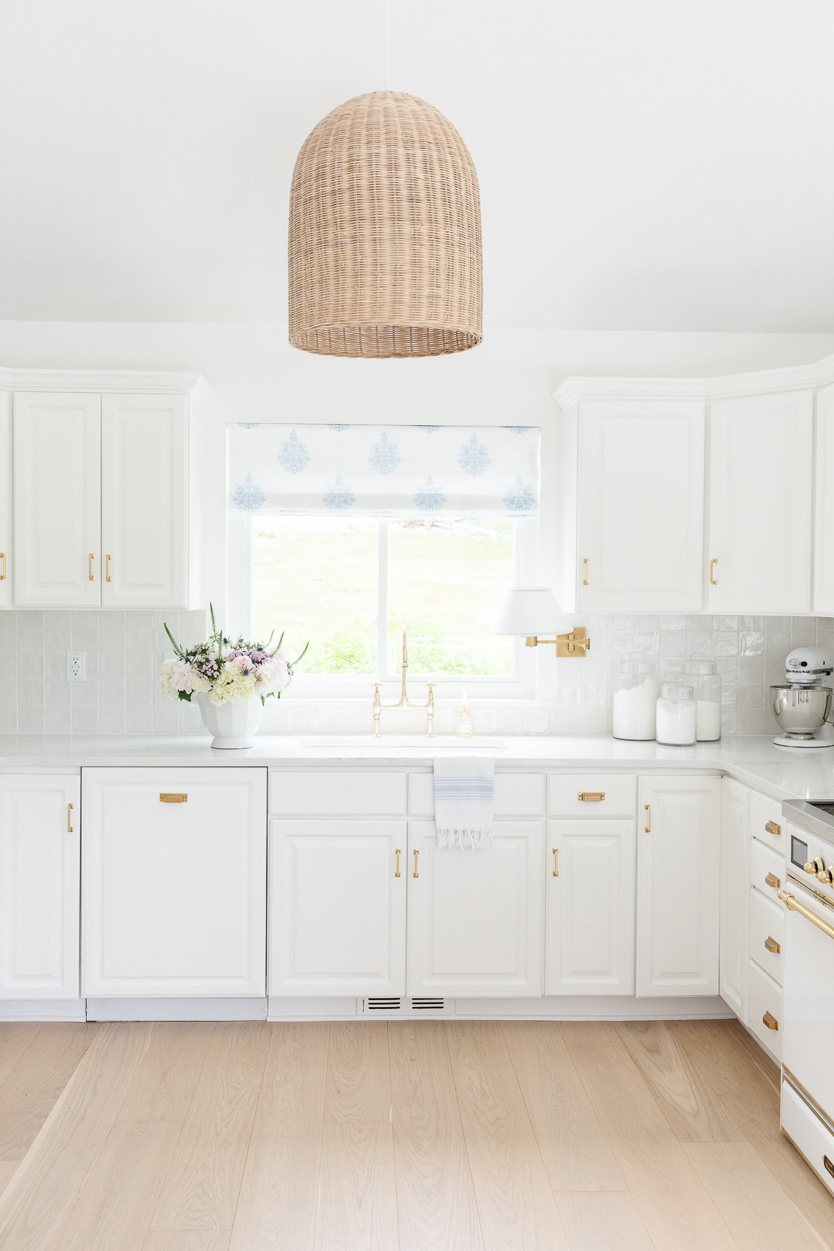 A white kitchen with rattan light fixture