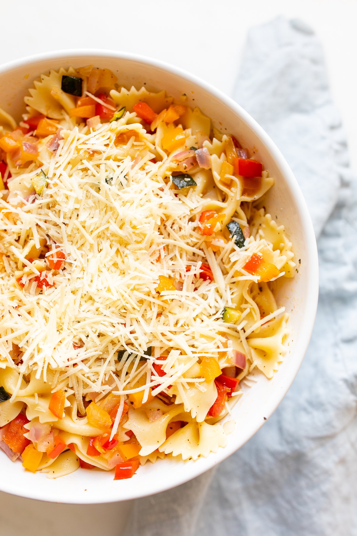 A white bowl full of veggie pasta salad. 