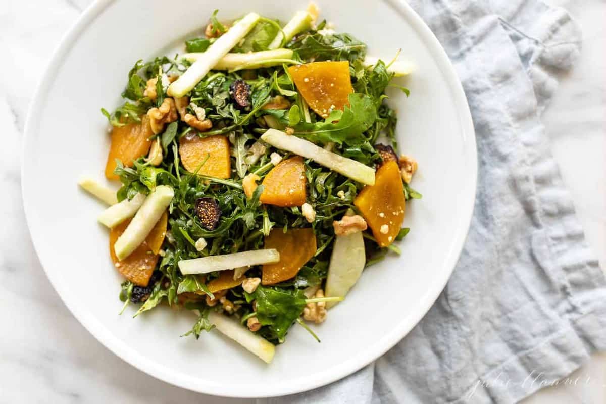 A white plate full of an easy beet salad recipe, topped with sliced jicama, dried figs, and roasted golden beets.