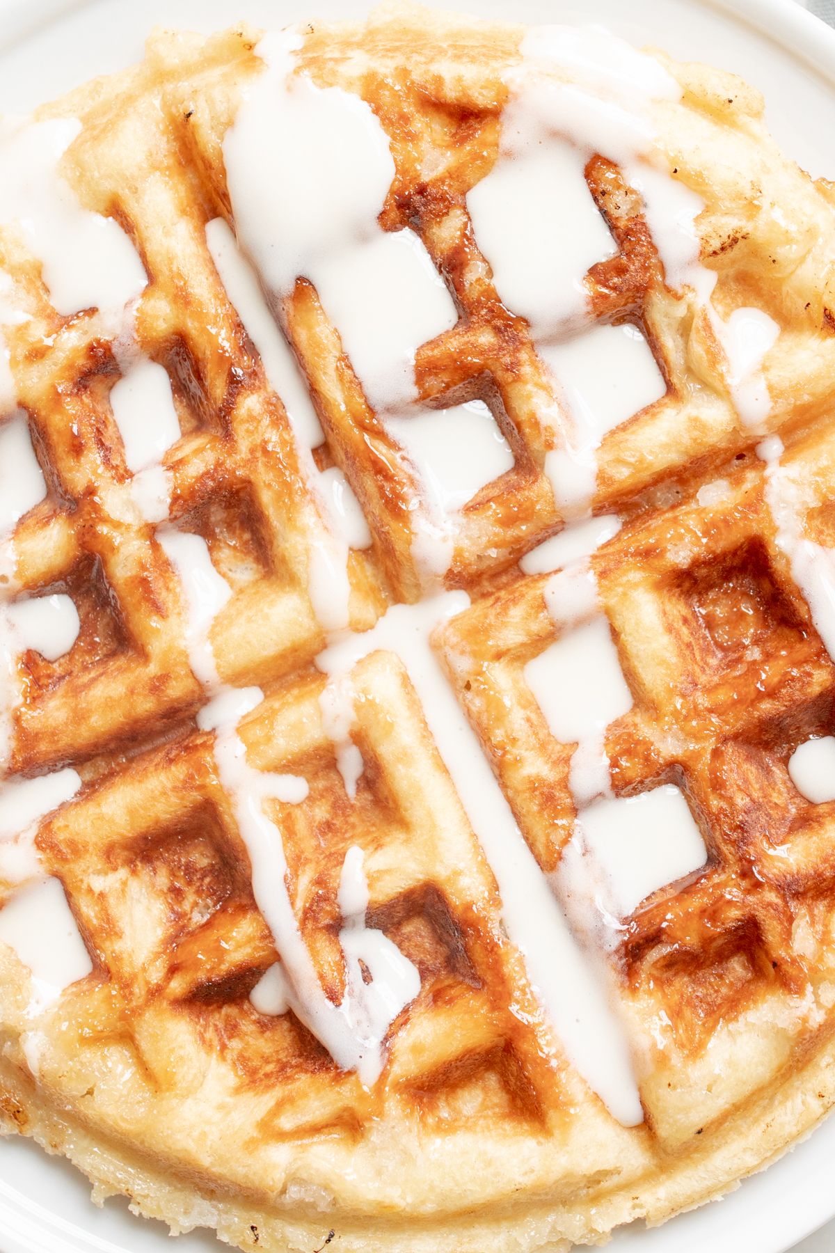 A close up of a Belgian waffle topped with creme fraiche.
