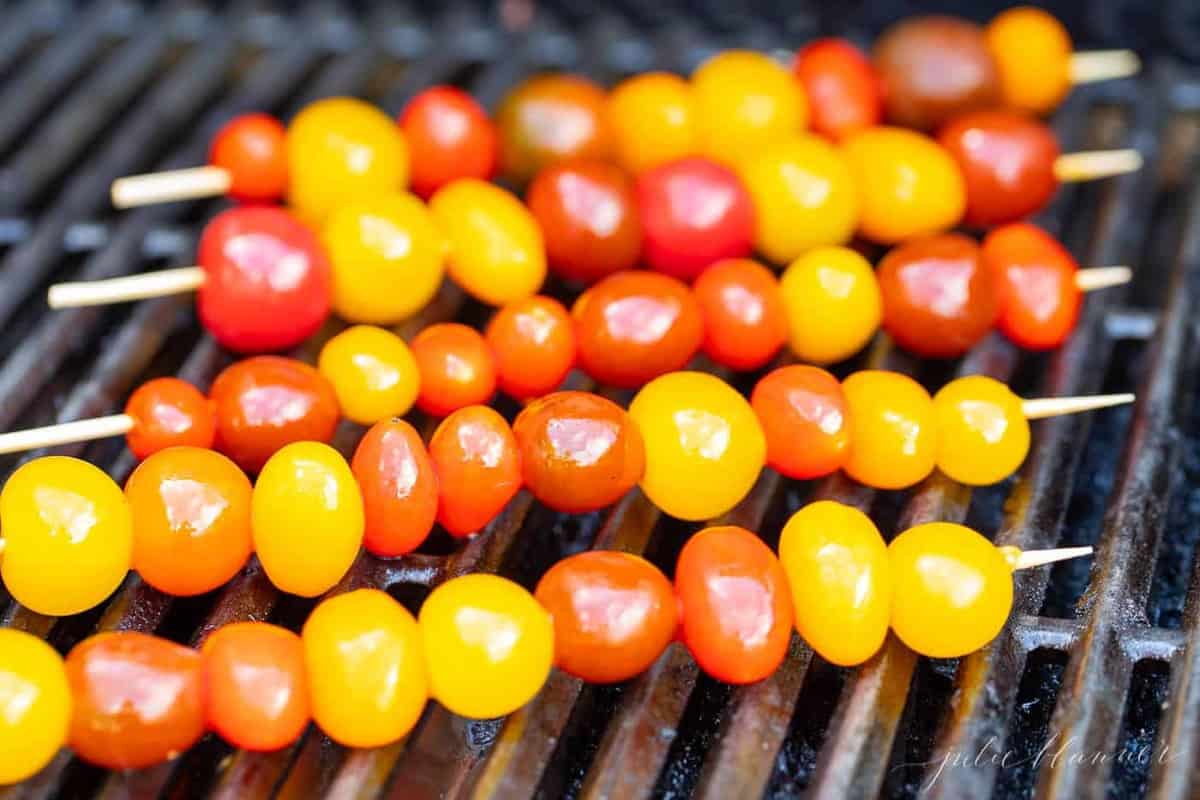 Cherry tomato skewers on a grill.