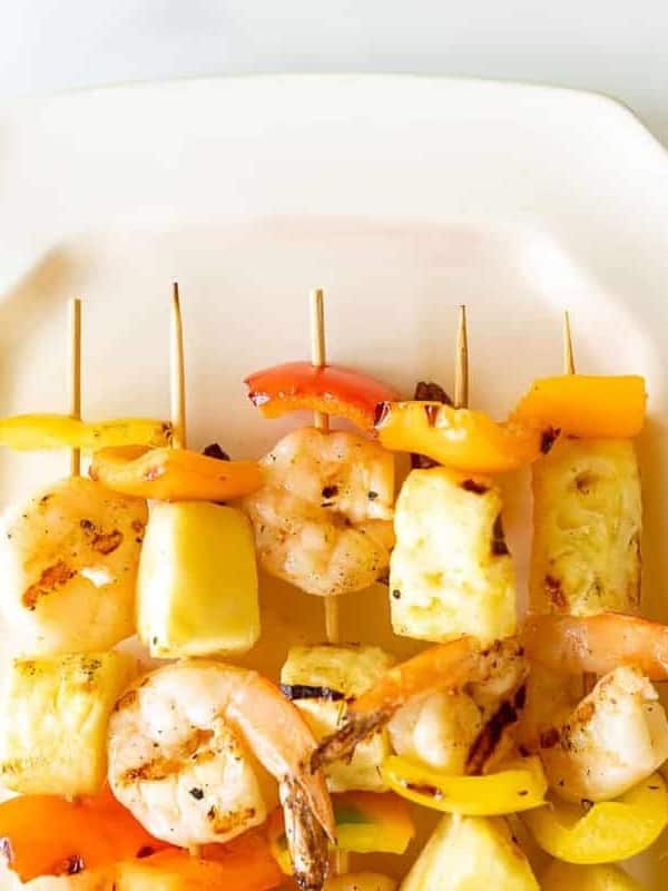 Pineapple shrimp skewers recipe on a white platter.