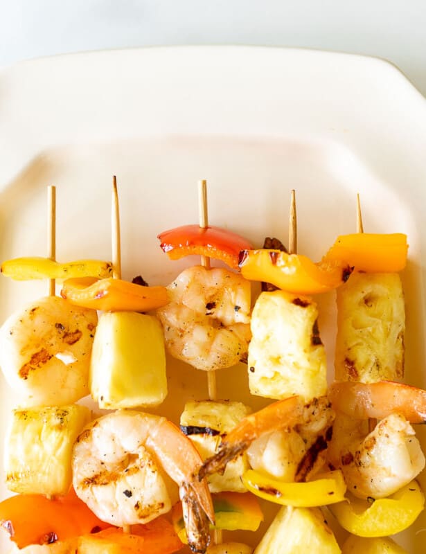 Pineapple shrimp skewers recipe on a white platter.