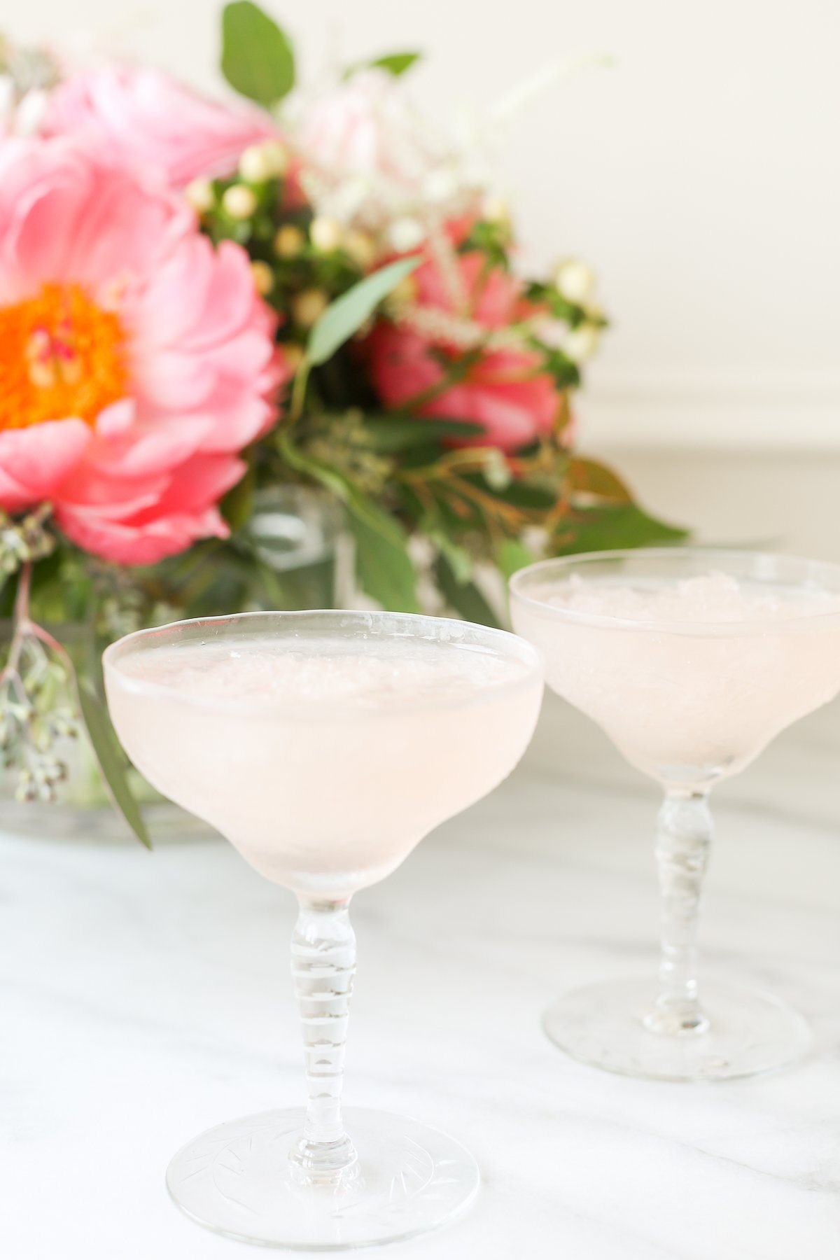 Two pink martinis in front of a frosé recipe.