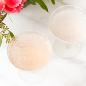 Two martini glasses with frosé and pink flowers.