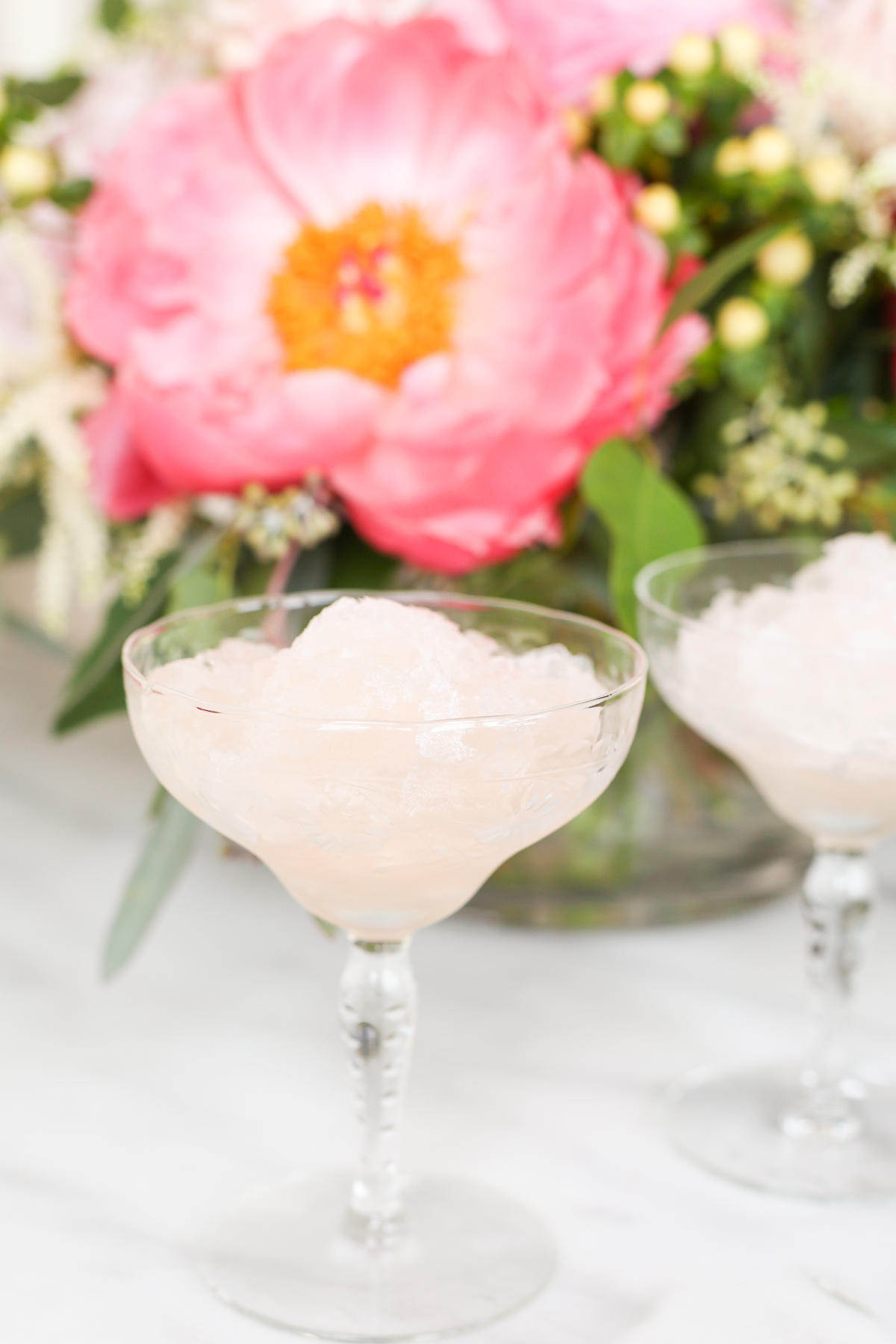 Two pink martini glasses filled with icy frosé, a refreshing cocktail made from a frosé recipe.