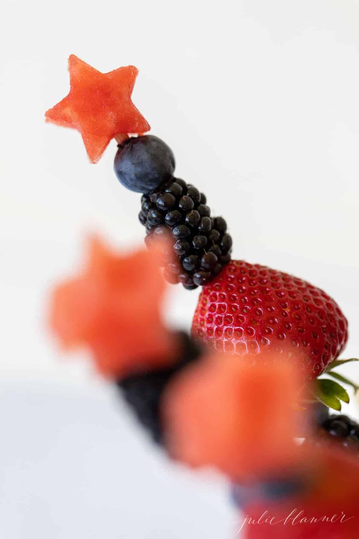 Close up of fourth of july inspired fresh fruit kabobs made of summer berries.