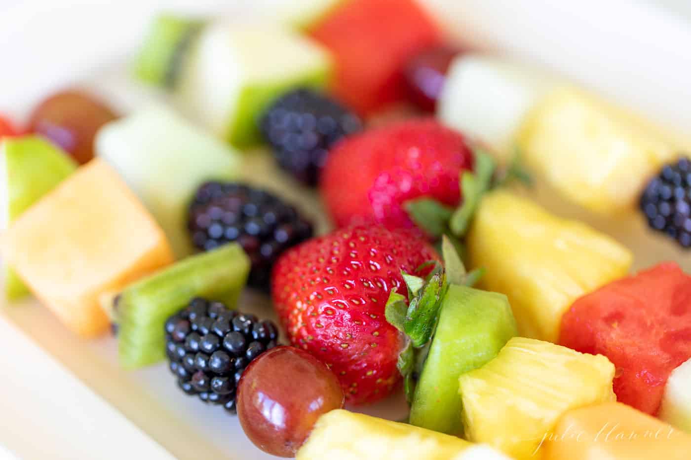 Close up of colorful fruit kebobs.