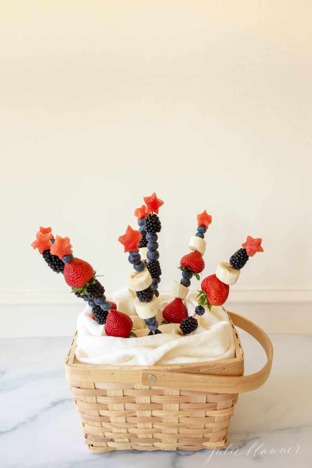 A marble surface with fruit skewers sticking out of the inside.