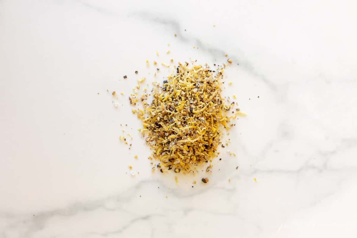 Marble surface with a small pile of homemade lemon pepper seasoning mix.