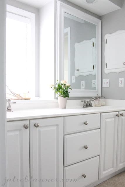 Bathroom with a white cabinet and gray walls.