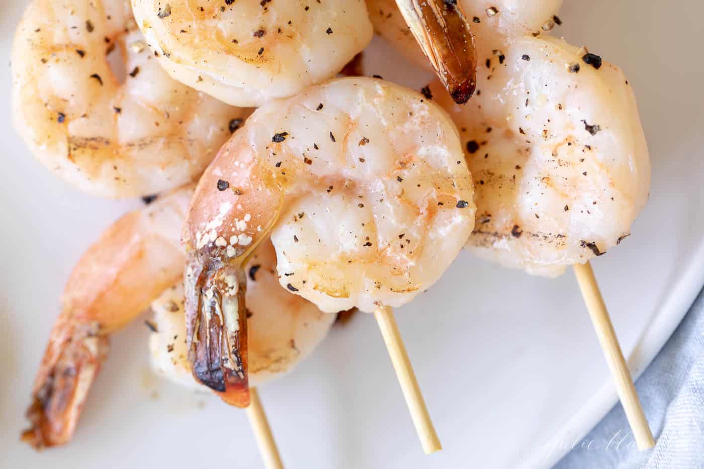 Close up of lemon garlic shrimp kabobs on bamboo skewers.