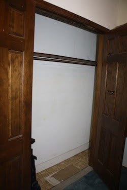 Old closet with dark wood doors.