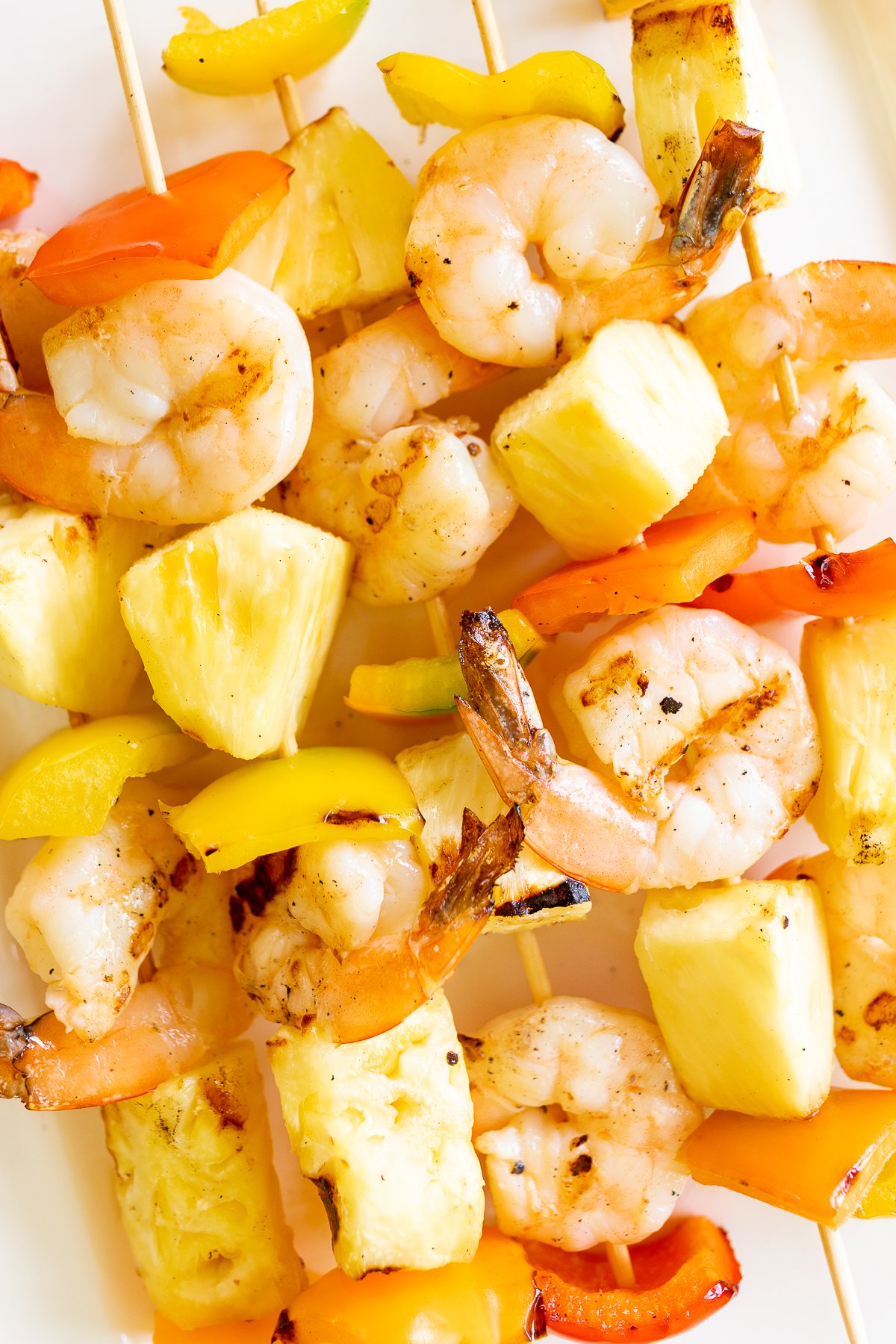Pineapple shrimp skewers on a plate.