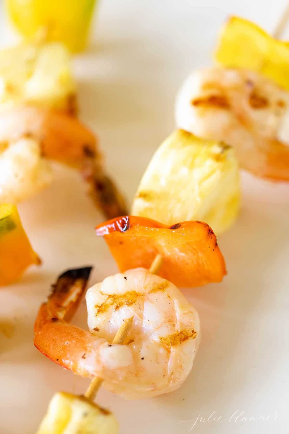 Close up shot of pineapple shrimp recipe on bamboo skewers.