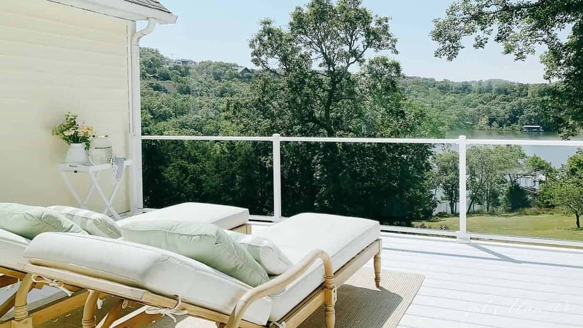 A white vinyl deck with lush trees in the background.