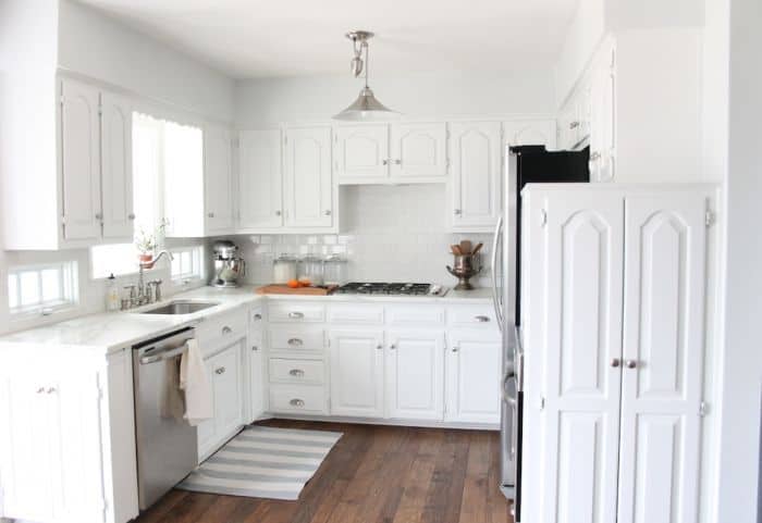 An all white kitchen with walls painted Sherwin Williams Rhinestone.