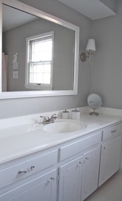 Bathroom with a white cabinet and gray walls.