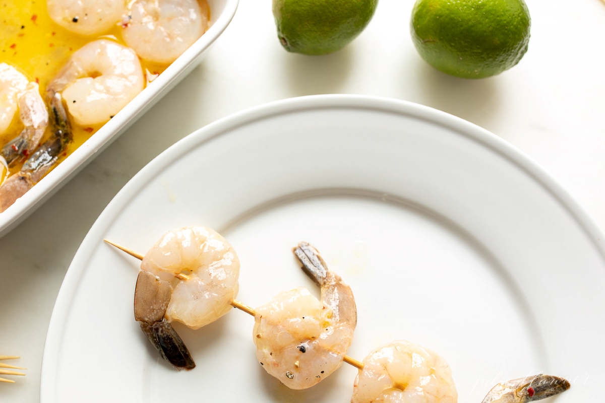 Tequila lime shrimp skewers on a white plate before cooking