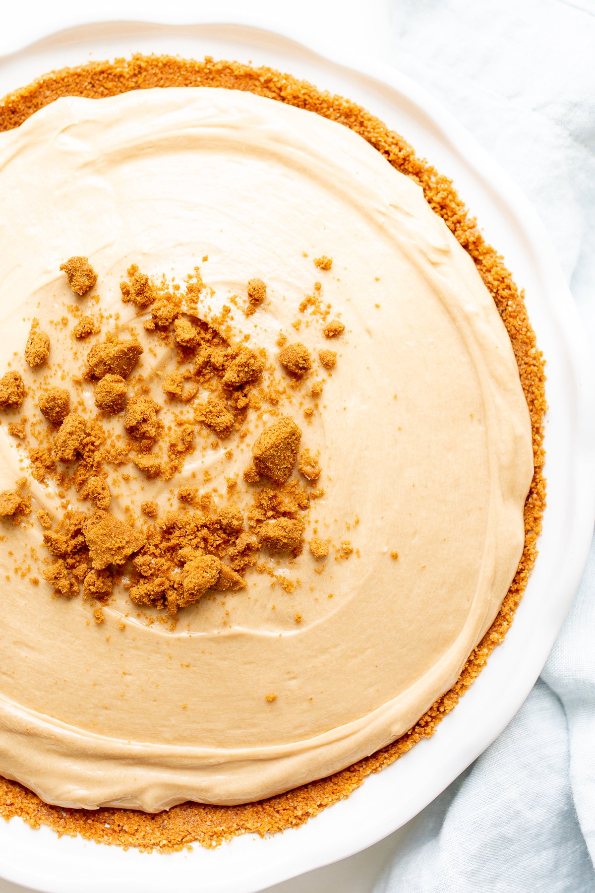 No bake cookie butter cheesecake in a white ceramic pie pan. 