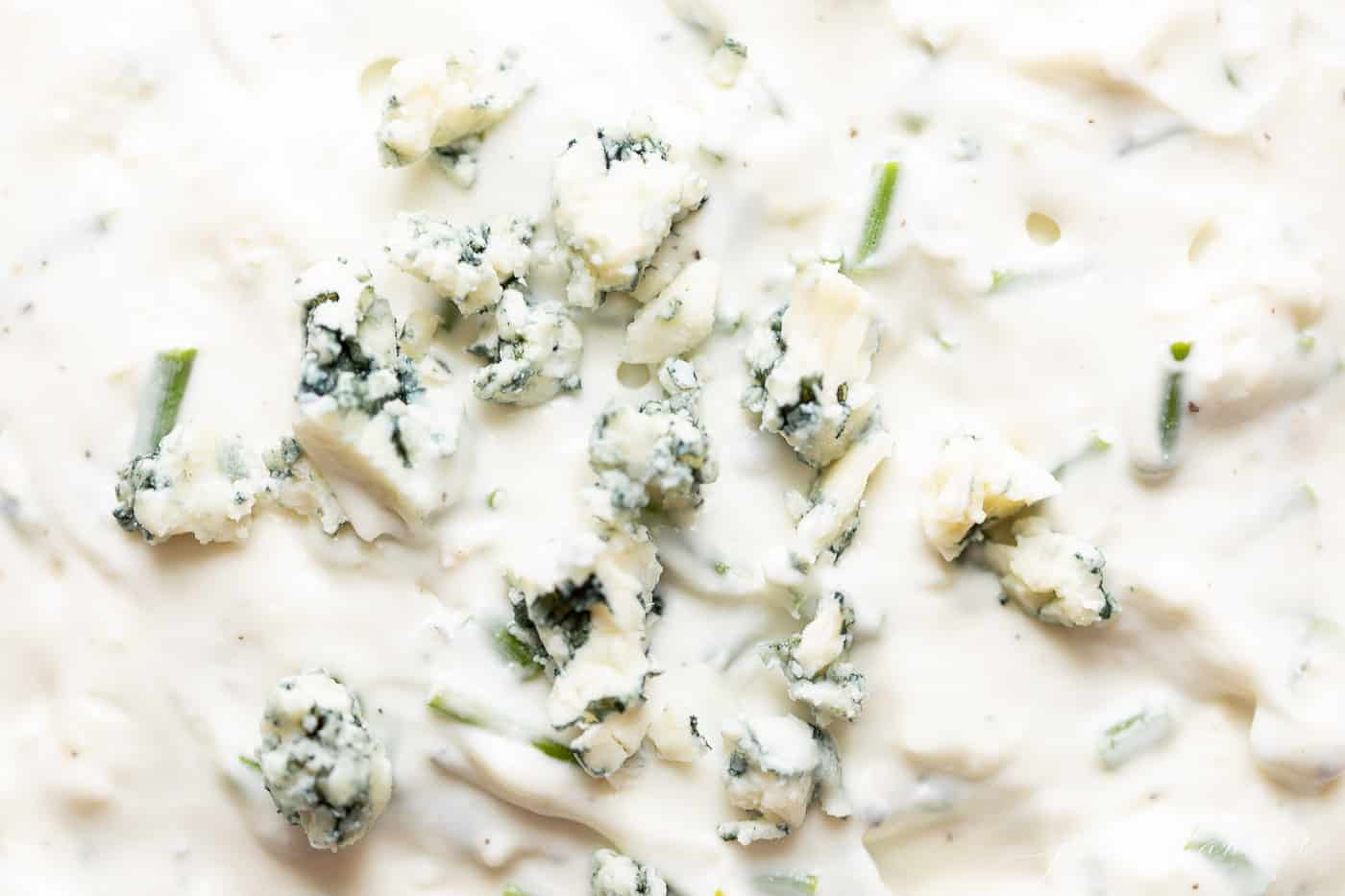 Easy and flavorful blue cheese dip recipe - the perfect starter for any gathering. Get the 5 minute start to finish recipe! close up of blue cheese garnishing dip