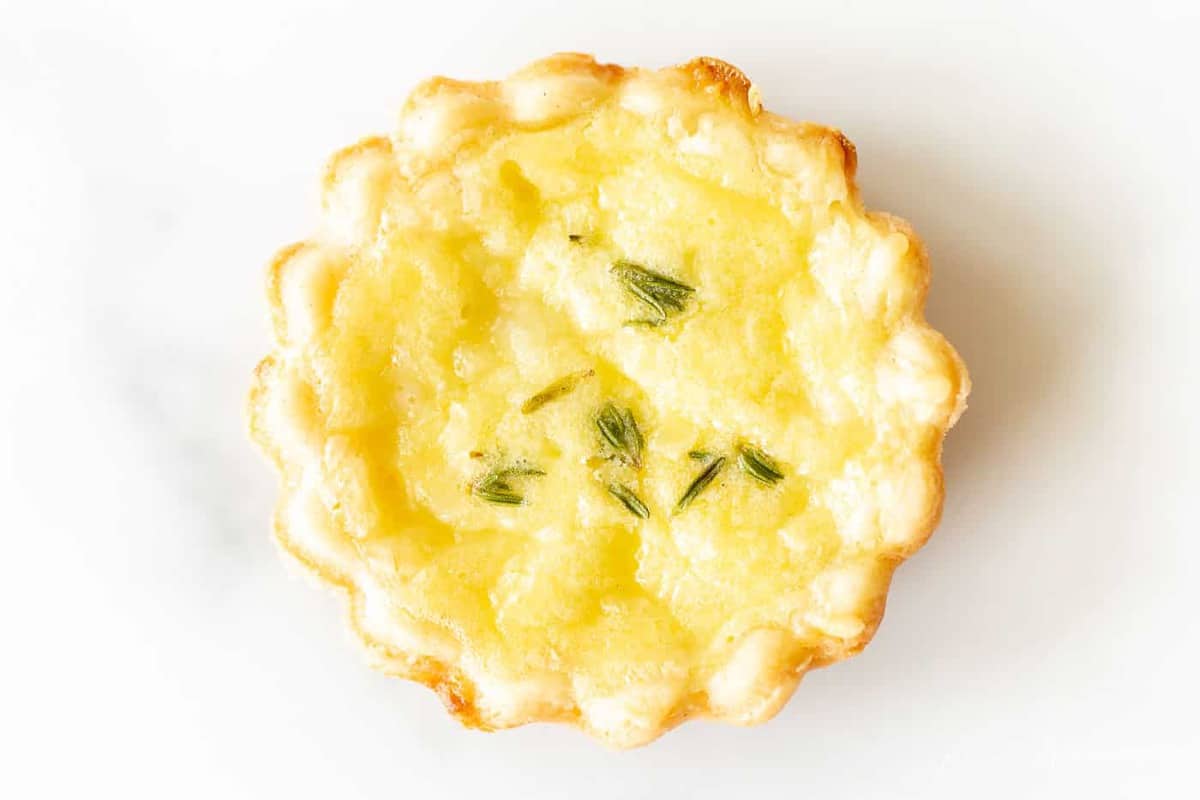 close up of cheese tart with thyme on top