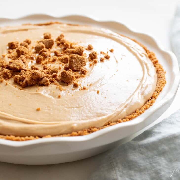 A white pie plate filled with a homemade no bake cookie butter cheesecake recipe.