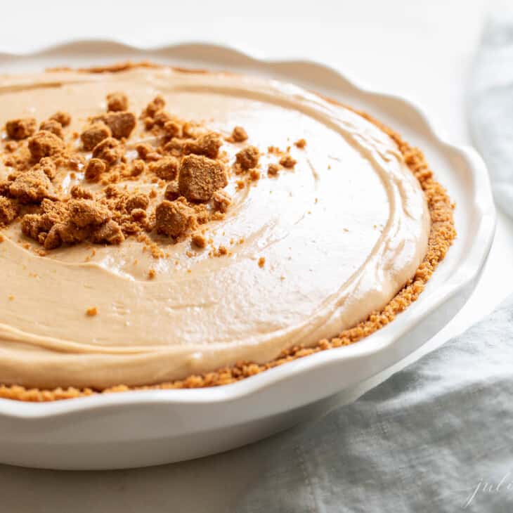 A white pie plate filled with a cookie butter cheesecake recipe.