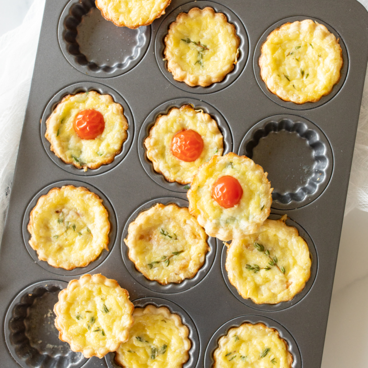 Mini cheese tarts in a baking pan, made with cream cheese pie crust.
