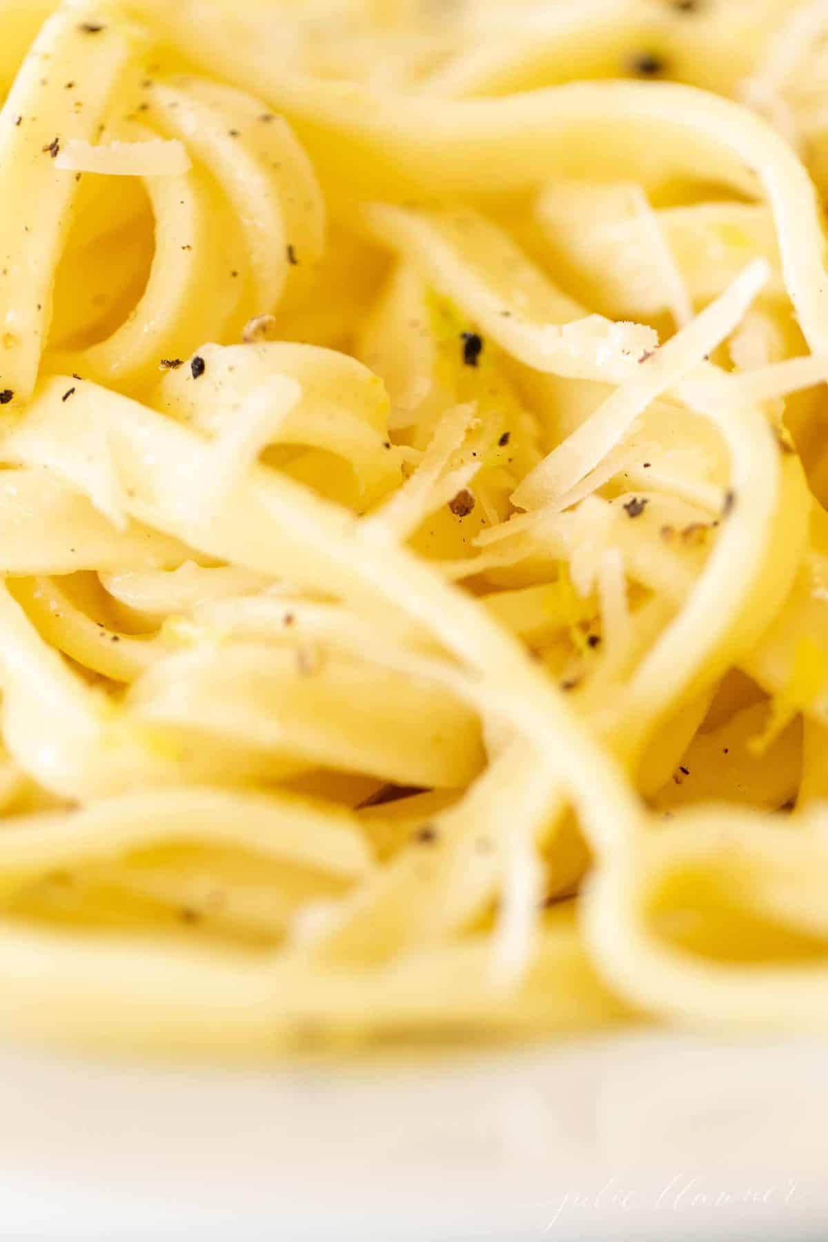 Close up shot of fettuccine noodles covered in a lemon pepper sauce.