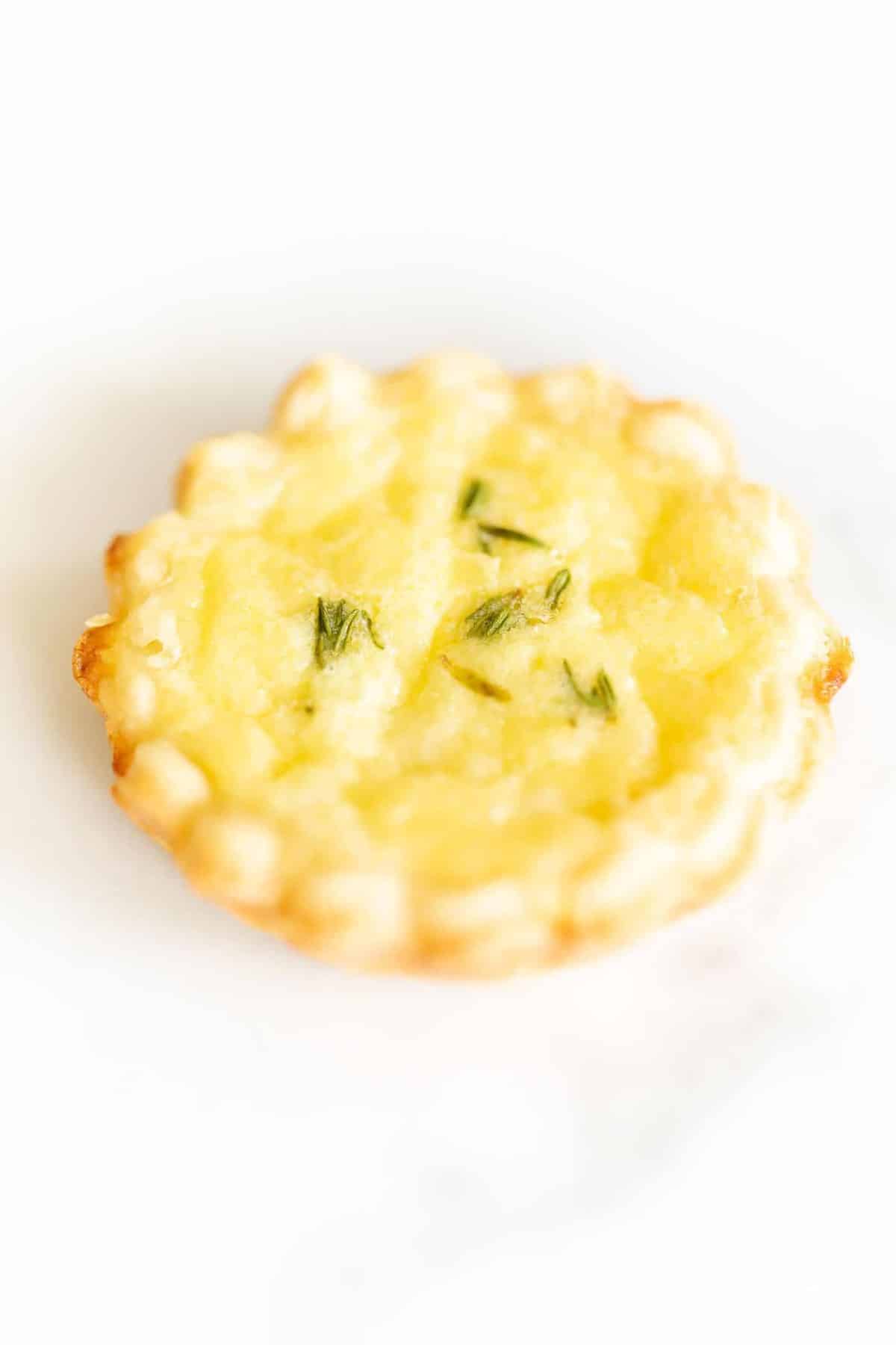 A small cheese tart with a cream cheese pie crust on a marble surface.