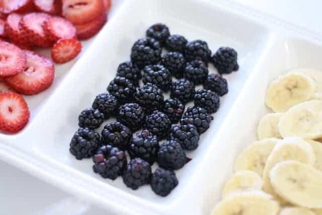 A white tray with fruit in each compartment