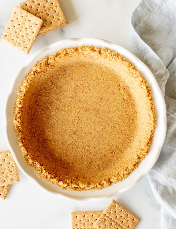 Graham cracker crust in a white pie plate.