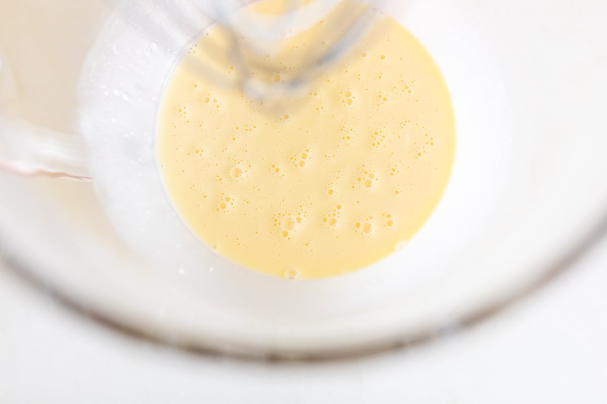 Looking into the bowl of a stand mixer, with cheese tart ingredients inside