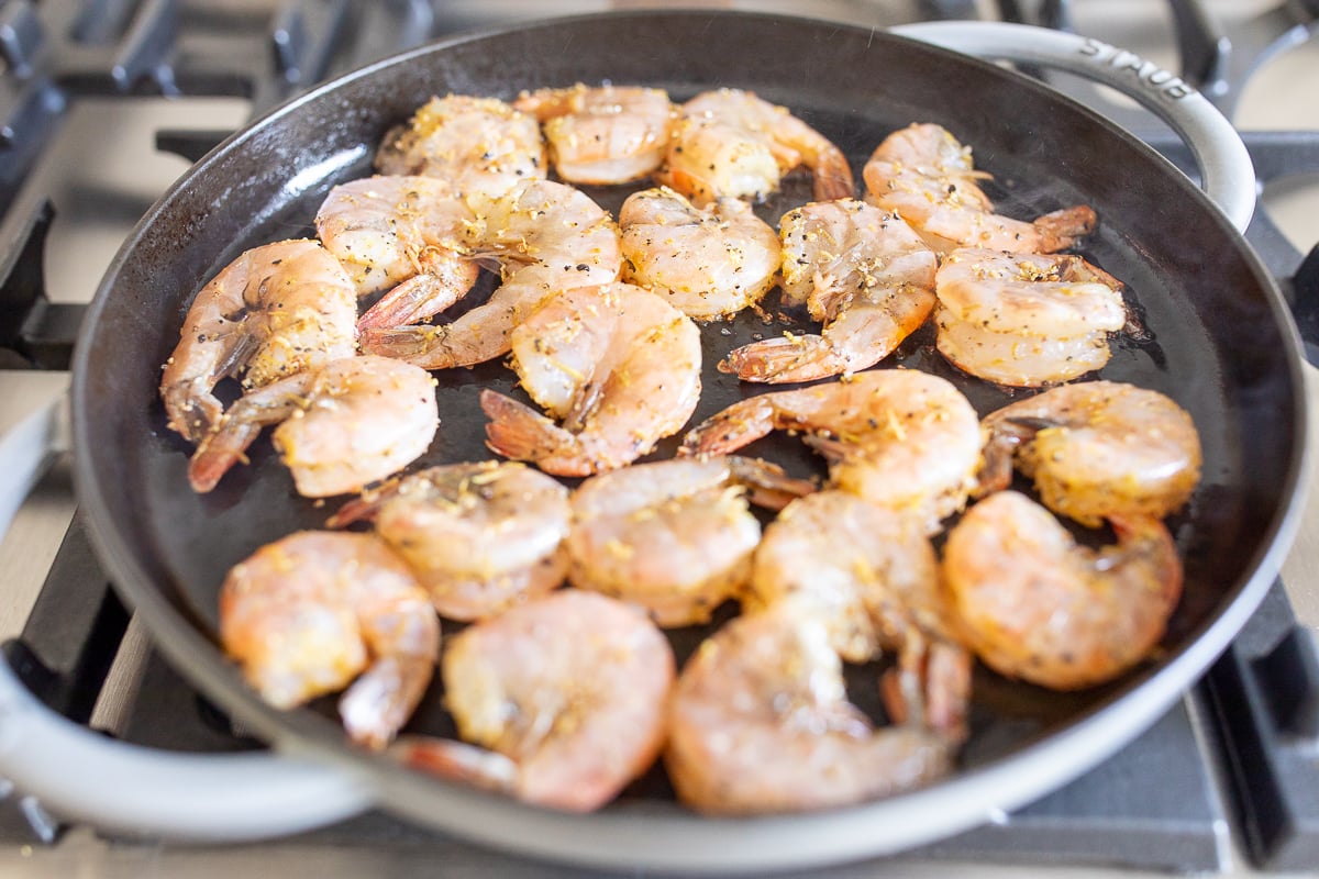 Shrimp cooking in a cast iron skillet.