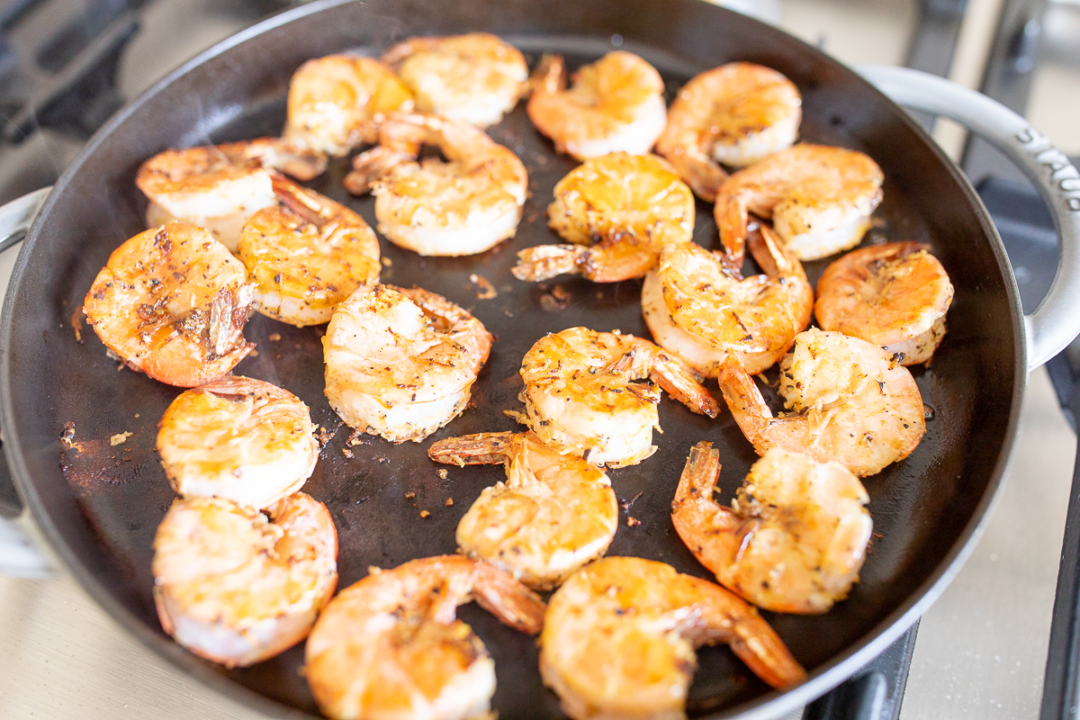 Shrimp cooking in a cast iron skillet.