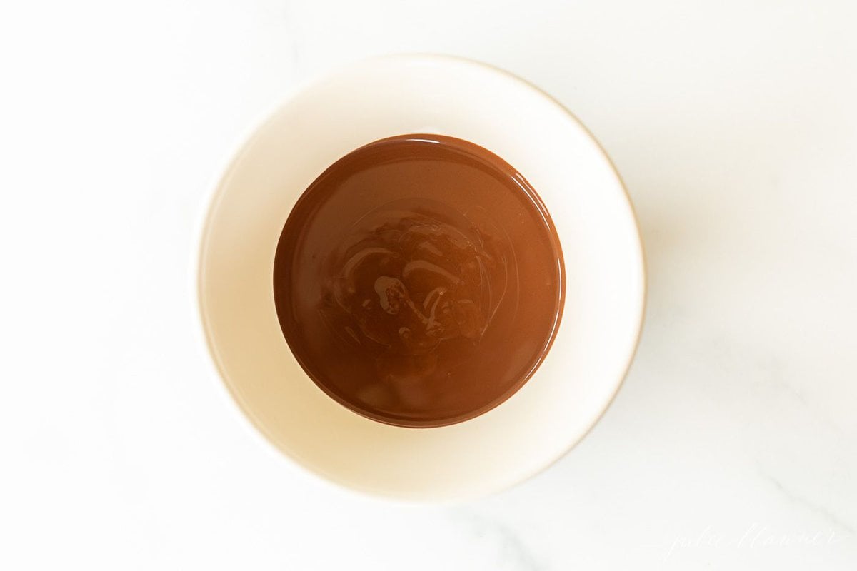 A white bowl of chocolate magic shell.