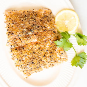 Lemon pepper salmon on a white platter.