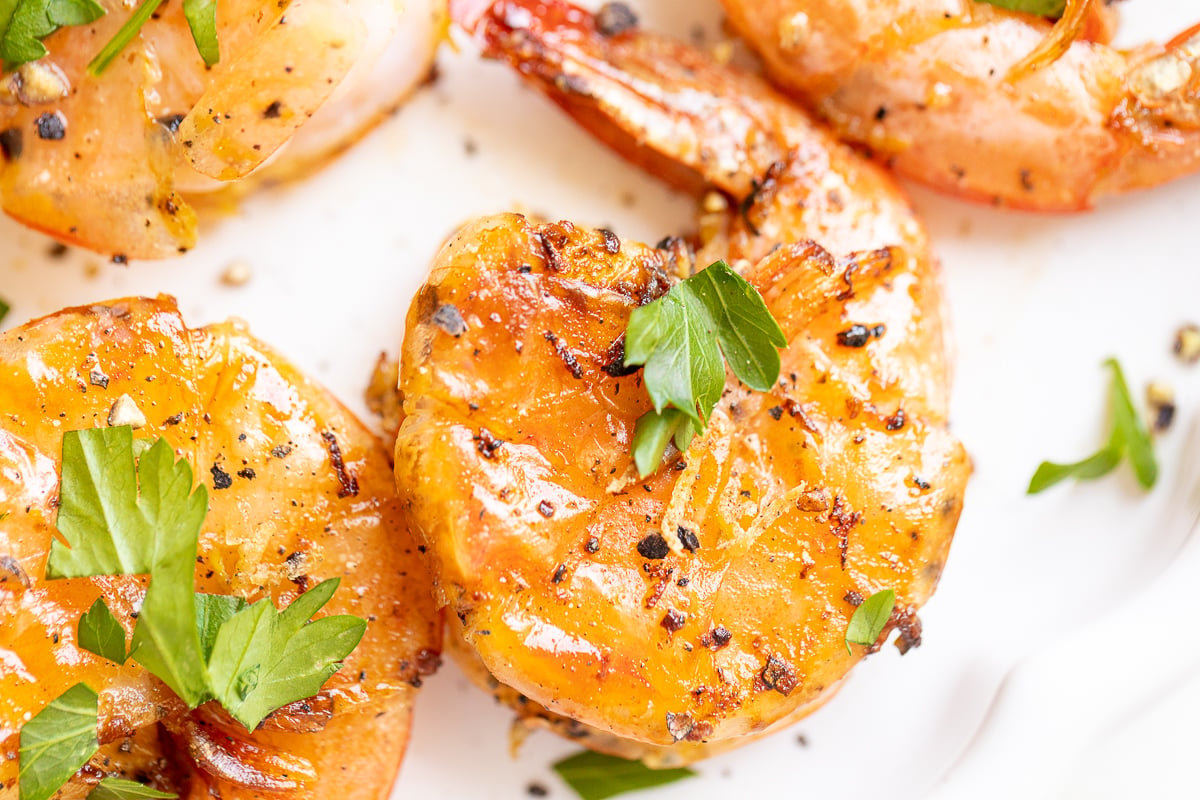 lemon pepper shrimp close up on a white plate.