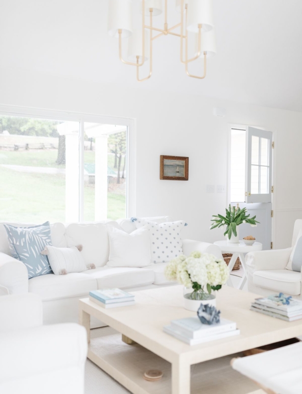 A white living room with white furniture and a raffia coffee table