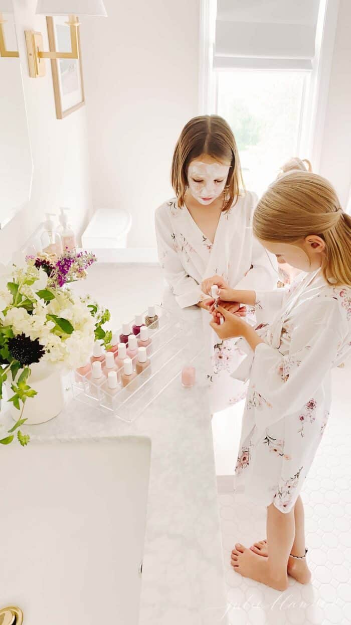 Two little girls having an at home spa day in a white bathroom