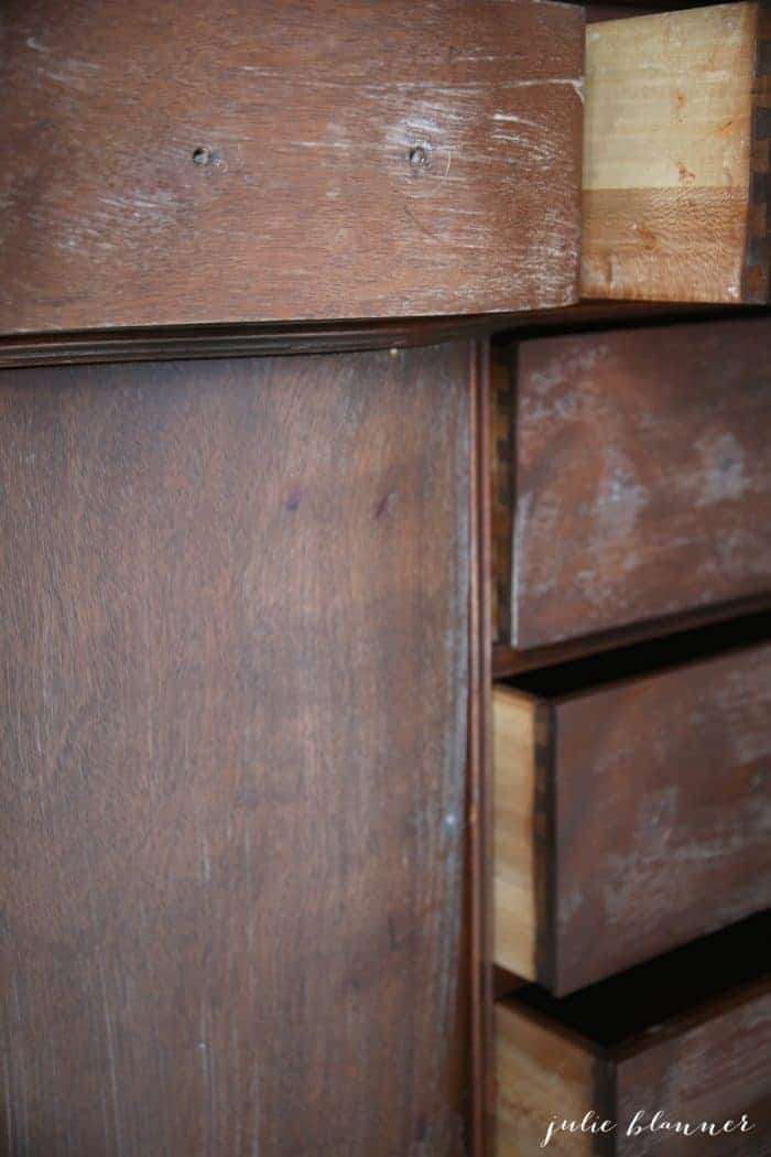 A wooden dresser covered in deglosser to prep for furniture paint.