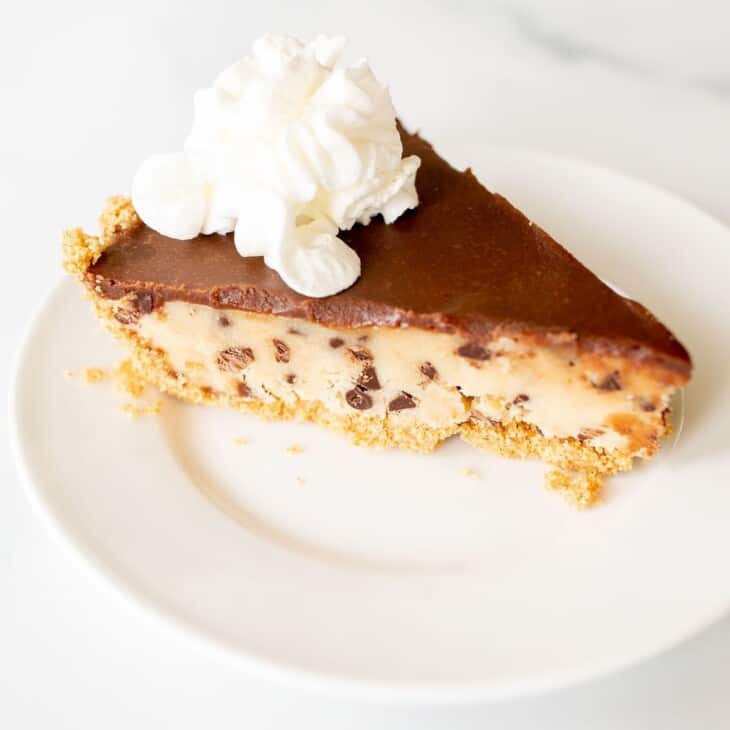 A slice of no bake cookie dough pie on a white plate.