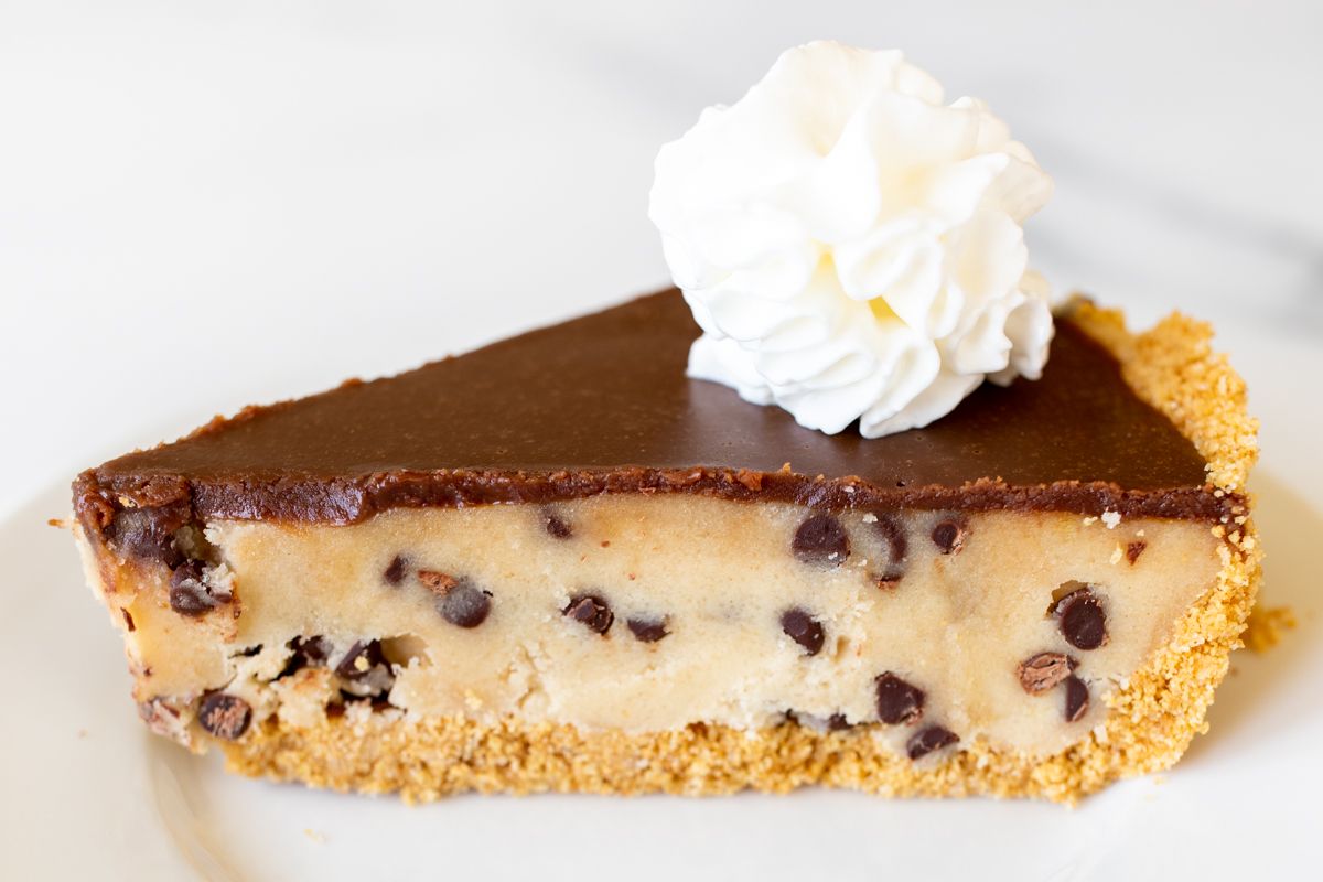 A white plate with a slice of cookie dough pie.