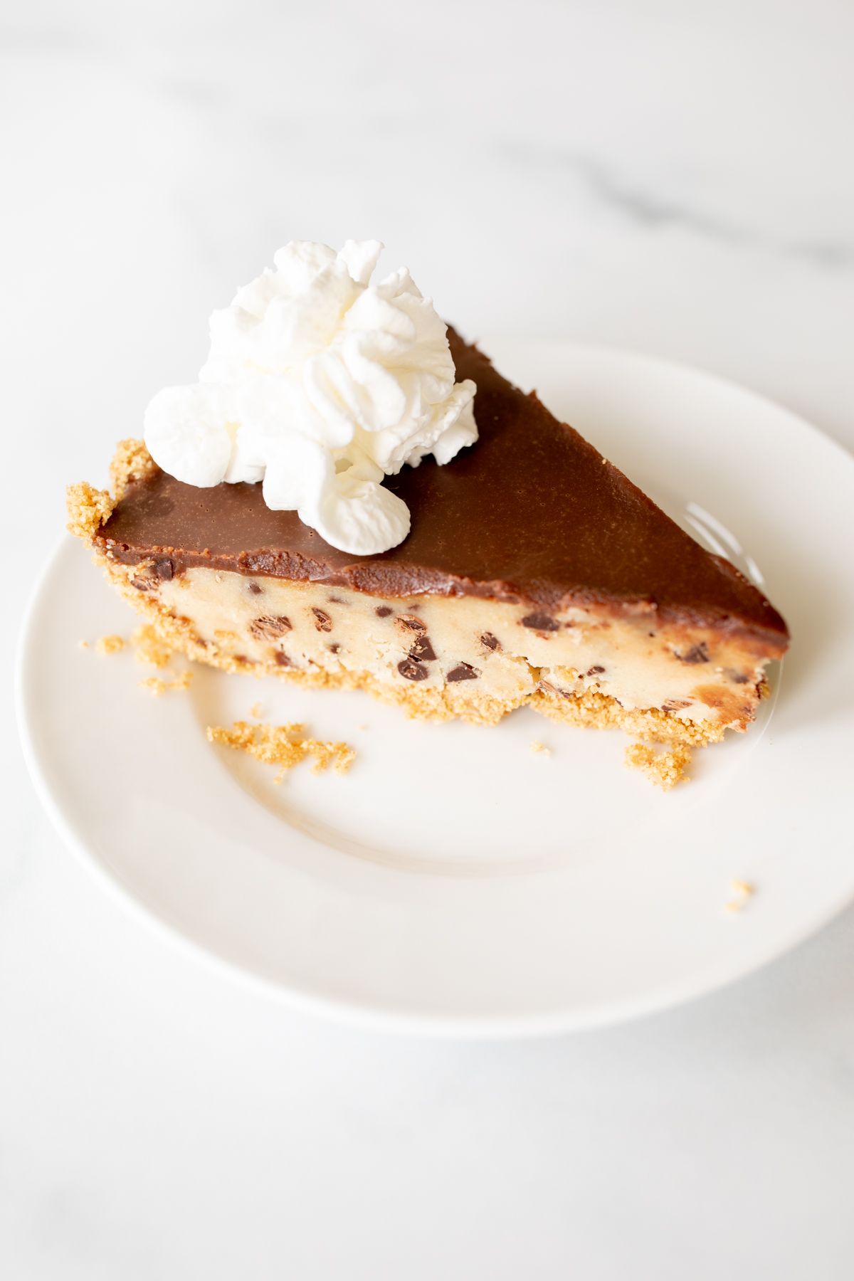 A white plate with a slice of cookie dough pie.