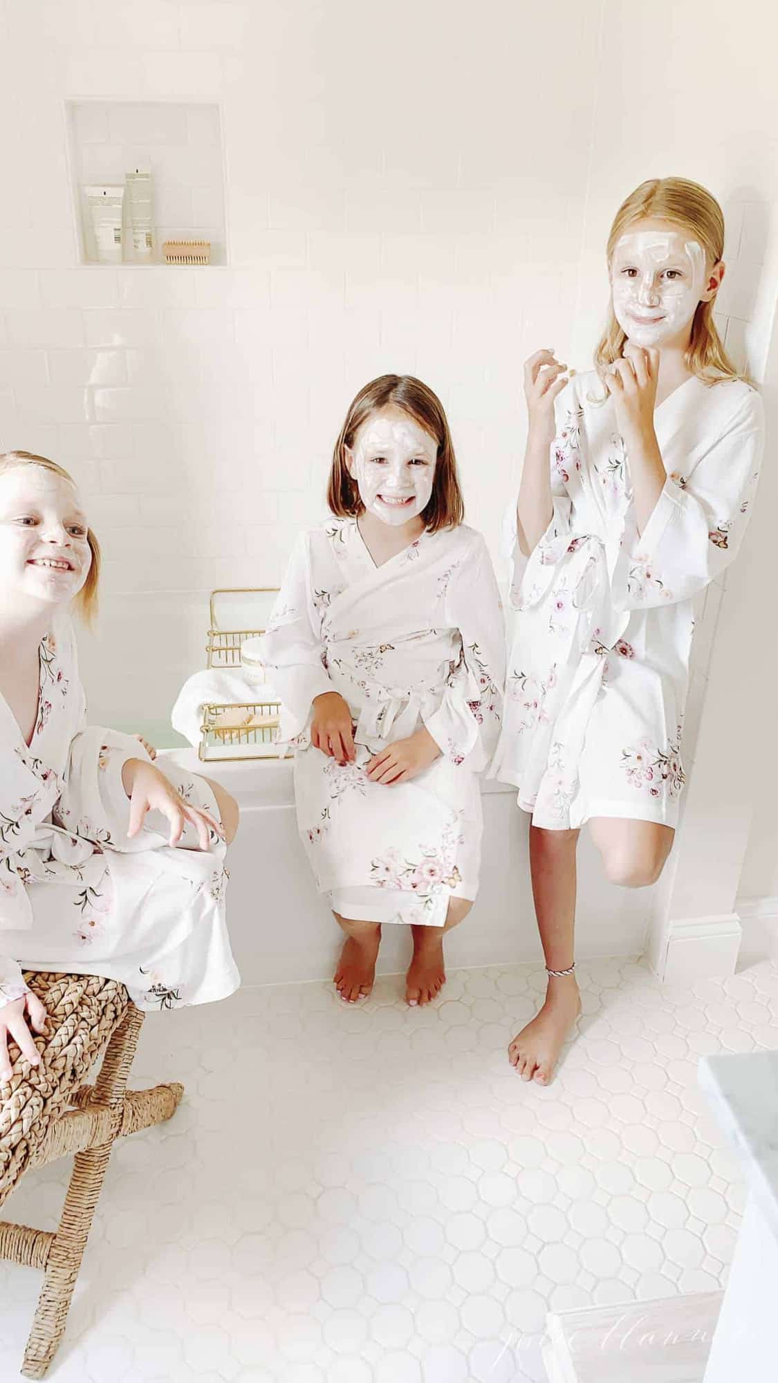 girls playing spa with face masks and robes next to air tub